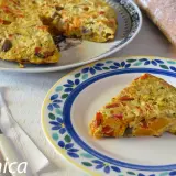 Deliciosa tortilla de berenjena con pimientos y calabaza, servida en un plato decorado.