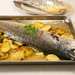 Corvina al horno con patatas y pimientos, lista para servir.