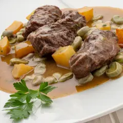 Carrilleras al horno, un plato de Karlos Arguiñano, con habas y trozos de calabaza en una salsa sabrosa.