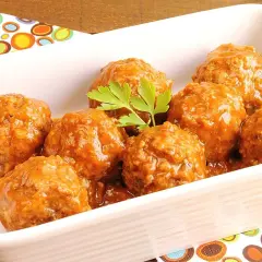 Albóndigas en salsa casera, servidas en una fuente blanca con perejil fresco.