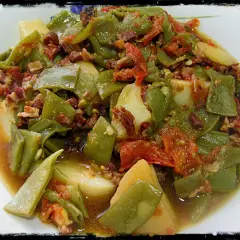 Judías verdes tiernas con patatas y trocitos de jamón, cocinadas en olla express. Un plato casero y sabroso.