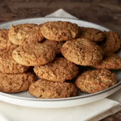 Montón de carajitos del profesor, galletas doradas y crujientes con avena y coco, apiladas en un plato gris.