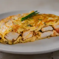Tortilla de bacalao, jugosa y dorada, con trozos de pescado blanco tierno envueltos en huevo.