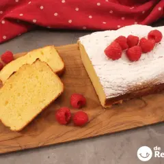 Bizcocho de leche casero, hecho con medida vaso, decorado con azúcar glas y frambuesas frescas. ¡Perfecto para merendar!