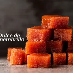 Cubos de dulce de membrillo apilados, con un brillo apetitoso.
