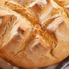 Pan rápido Thermomix, dorado y crujiente, con cortes en forma de rombos y espolvoreado de harina.