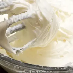 Batidora mezclando un cremoso frosting de queso, listo para decorar.