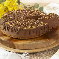 Tarta de chocolate y queso mascarpone sin horno, cubierta con frutos secos y un glaseado de chocolate. ¡Una delicia cremosa!