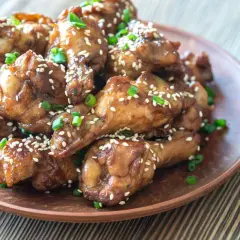 Alitas de pollo glaseadas con salsa de la abuela, espolvoreadas con semillas de sésamo y cebollín. ¡Un manjar casero!