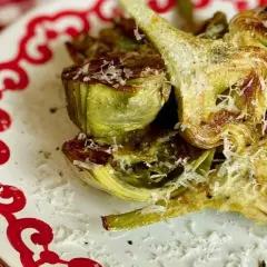Deliciosas alcachofas hervidas, cortadas y gratinadas con queso rallado, listas para disfrutar. Ideales para tus recetas con alcachofas hervidas.