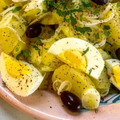Ensalada de patatas cocidas con huevo duro, aceitunas negras y perejil. Una opción deliciosa para tus recetas con patatas cocidas.