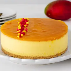 Deliciosa tarta de mango con una capa superior de gelatina brillante y decorada con grageas rojas y amarillas.