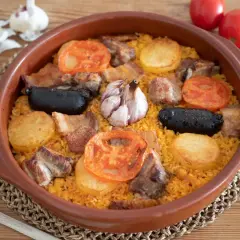 Arroz al horno con costillas, morcilla, patatas y tomates. El tiempo y temperatura perfectos para un plato delicioso.