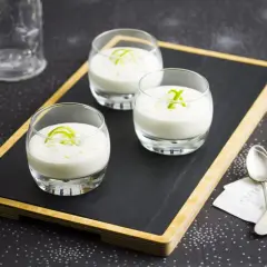 Tres vasitos de cremoso mousse de limón, decorados con ralladura verde, listos para disfrutar.