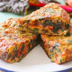 Tortilla de acelgas casera, jugosa y dorada, con trozos de verdura bien integrados.