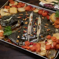 Rodaballo al horno con patatas, tomates cherry y ajo, un plato que evoca la cocina de Arzak.
