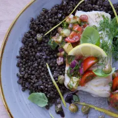 Filete de bacalao con ensalada de tomate y pepino, acompañado de lentejas. Una de las mejores recetas de bacalao.