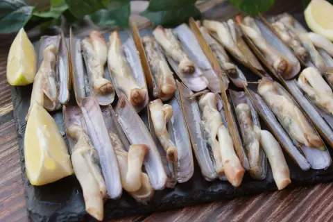 Navajas a la plancha, listas para disfrutar. Un plato de marisco fresco con toques de limón.