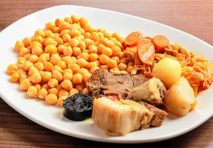 Plato de cocido en olla express con garbanzos, carne, morcilla, patatas y verduras.