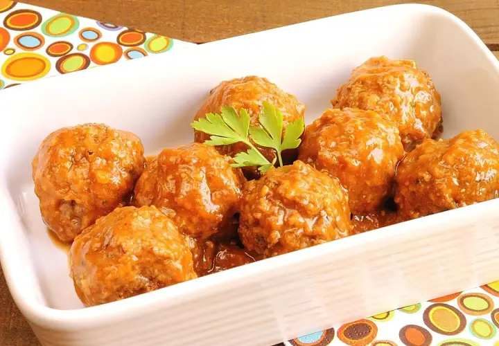 Albóndigas en salsa casera, servidas en una fuente blanca con perejil fresco.