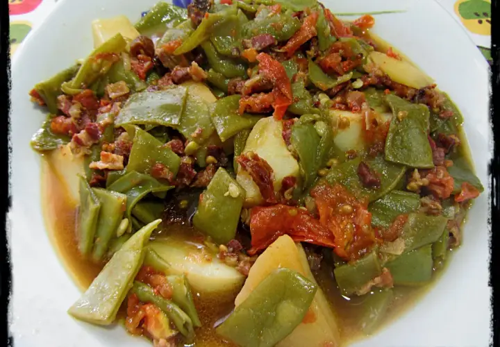 Judías verdes tiernas con patatas y trocitos de jamón, cocinadas en olla express. Un plato casero y sabroso.