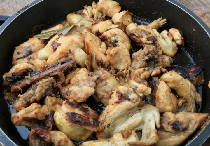 Sabroso pollo al ajillo arguiñano en sartén, con trozos dorados y jugosos, listos para disfrutar.