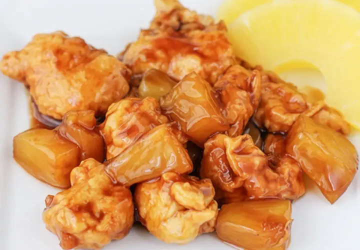 Sabroso pollo con piña en salsa agridulce, con trozos de piña dorada y jugosa.