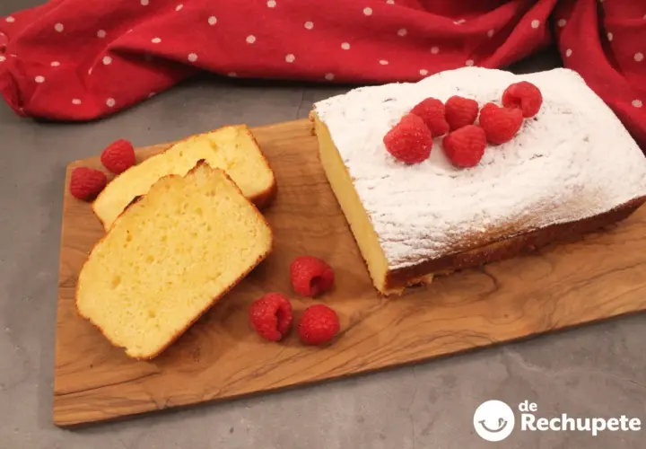 Bizcocho de leche casero, hecho con medida vaso, decorado con azúcar glas y frambuesas frescas. ¡Perfecto para merendar!