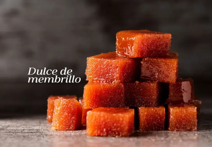 Cubos de dulce de membrillo apilados, con un brillo apetitoso.