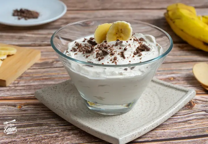 Delicioso mousse de plátano cremoso, adornado con trozos de chocolate y rodajas de plátano fresco.