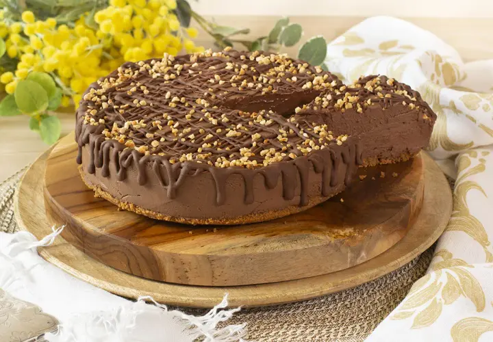 Tarta de chocolate y queso mascarpone sin horno, cubierta con frutos secos y un glaseado de chocolate. ¡Una delicia cremosa!
