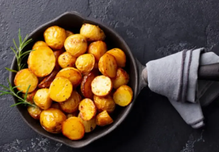 Patatas doradas y crujientes en una sartén, listas para servir. Un toque de romero realza el aroma de estas patatas olla express.