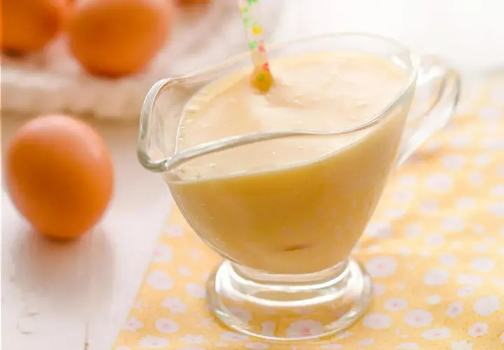 Crema pastelera perfecta hecha en Thermomix, lista para usar. Huevos frescos en el fondo.