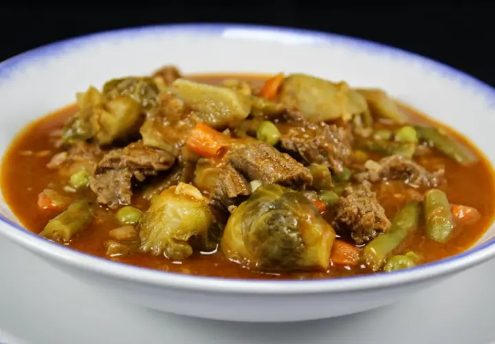 Un reconfortante plato de menestra de verduras con carne de la abuela, lleno de tiernos trozos de carne, coles de Bruselas, zanahorias y judías verdes en una rica salsa.