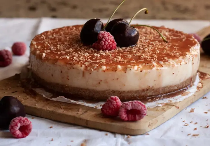 Tarta de queso con leche condensada, cubierta de frutos rojos y virutas de chocolate. ¡Un postre irresistible!