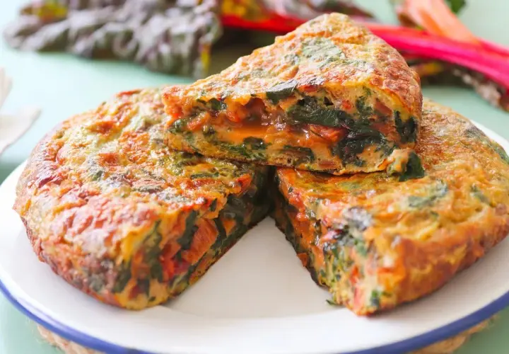 Tortilla de acelgas casera, jugosa y dorada, con trozos de verdura bien integrados.