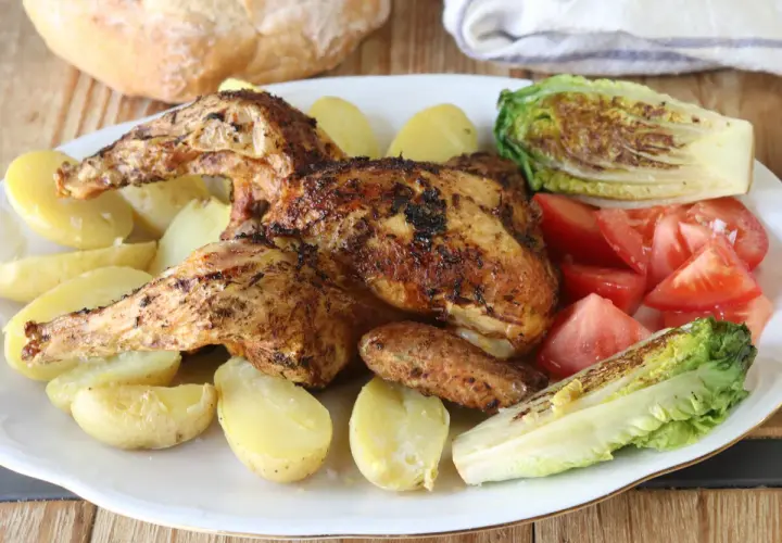 Pollo a la brasa jugoso y dorado, acompañado de papas amarillas, tomates frescos y lechuga a la parrilla. Un festín para disfrutar.