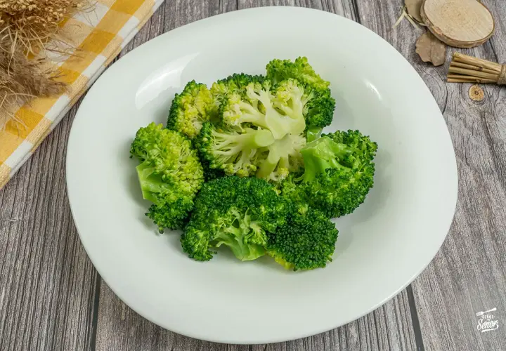 Brocoli al vapor, fresco y verde, servido en un plato blanco. Un toque saludable y delicioso.