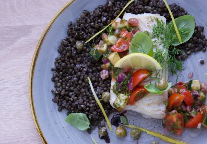 Filete de bacalao con ensalada de tomate y pepino, acompañado de lentejas. Una de las mejores recetas de bacalao.