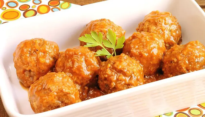 Albóndigas en salsa casera, servidas en una fuente blanca con perejil fresco.