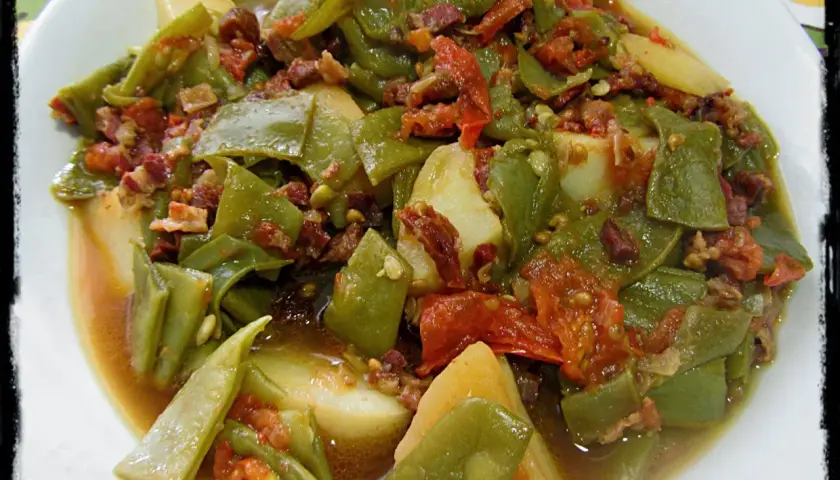 Judías verdes tiernas con patatas y trocitos de jamón, cocinadas en olla express. Un plato casero y sabroso.