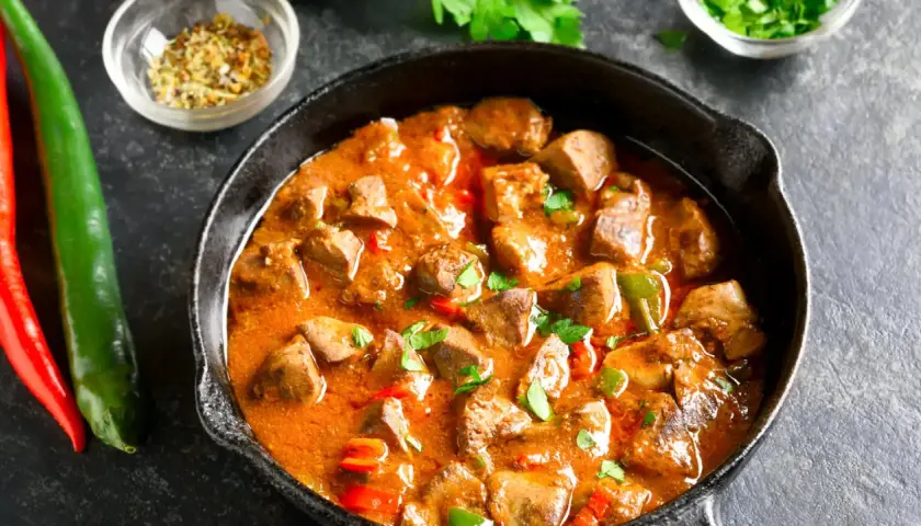 Sabroso pollo guisado arguiñano en sartén, con pimientos y especias. ¡Un plato casero que huele delicioso!
