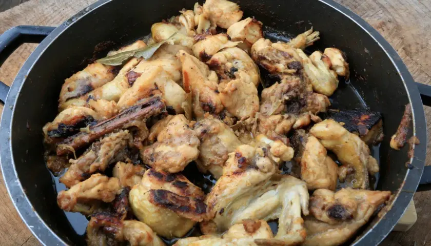 Sabroso pollo al ajillo arguiñano en sartén, con trozos dorados y jugosos, listos para disfrutar.