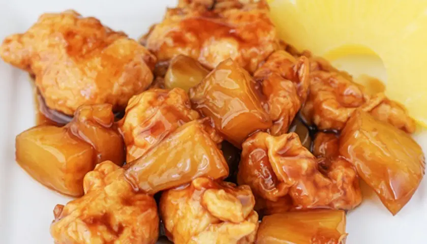 Sabroso pollo con piña en salsa agridulce, con trozos de piña dorada y jugosa.