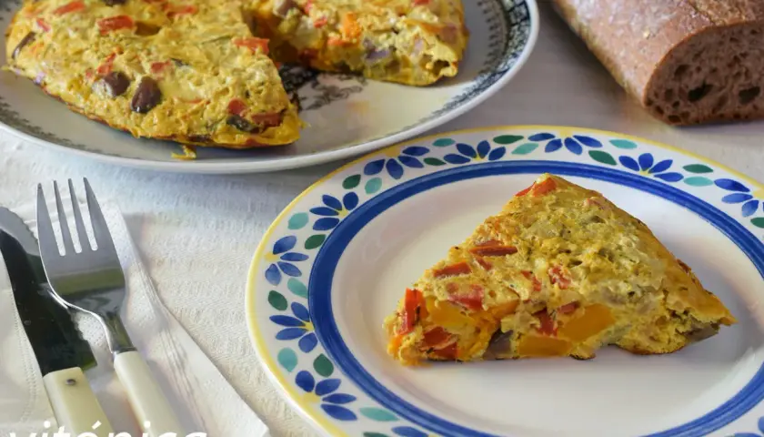 Deliciosa tortilla de berenjena con pimientos y calabaza, servida en un plato decorado.