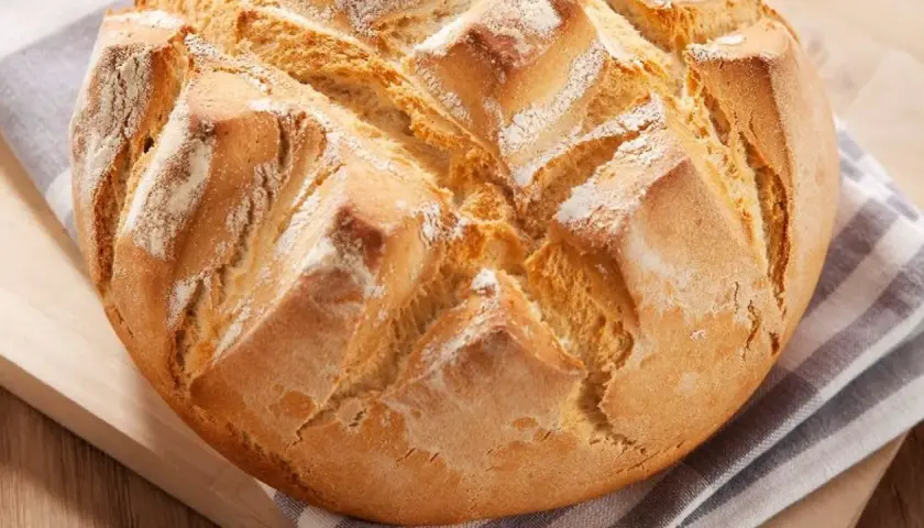 Pan rápido Thermomix, dorado y crujiente, con cortes en forma de rombos y espolvoreado de harina.