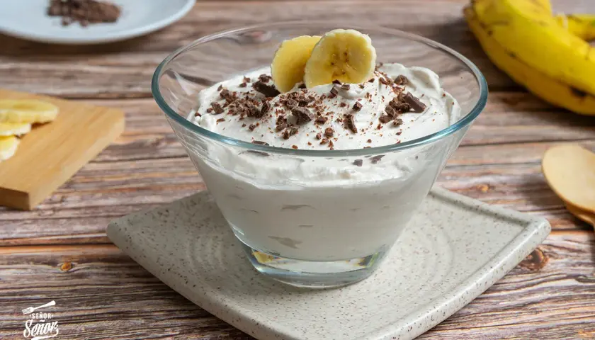 Delicioso mousse de plátano cremoso, adornado con trozos de chocolate y rodajas de plátano fresco.