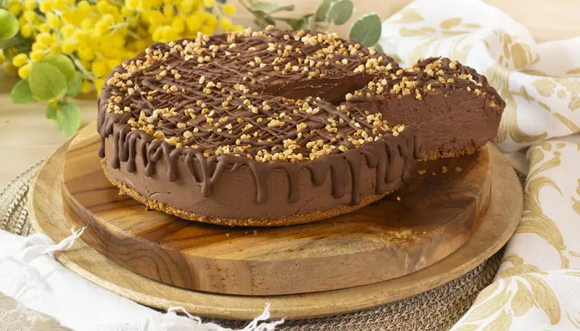 Tarta de chocolate y queso mascarpone sin horno, cubierta con frutos secos y un glaseado de chocolate. ¡Una delicia cremosa!