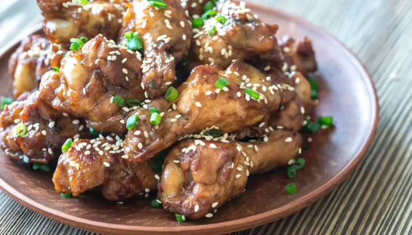 Alitas de pollo glaseadas con salsa de la abuela, espolvoreadas con semillas de sésamo y cebollín. ¡Un manjar casero!