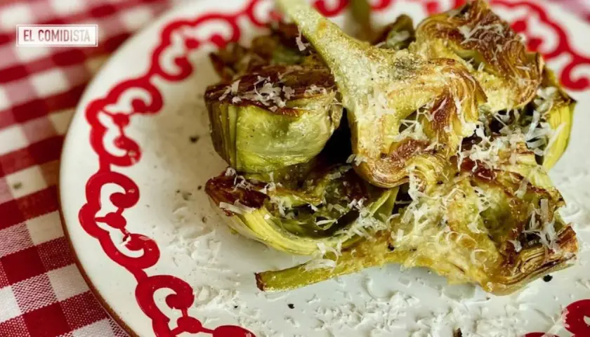 Deliciosas alcachofas hervidas, cortadas y gratinadas con queso rallado, listas para disfrutar. Ideales para tus recetas con alcachofas hervidas.